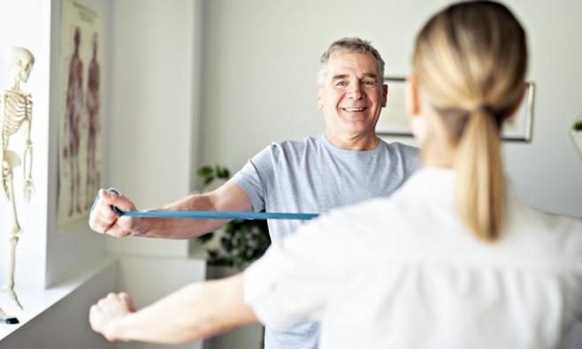 Patient führt Übung mit Band durch