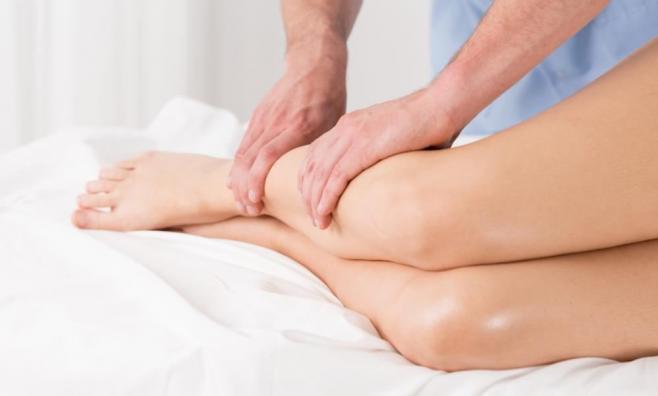 Physiotheraputin führt Lymphdrainage am Unterschenkel durch